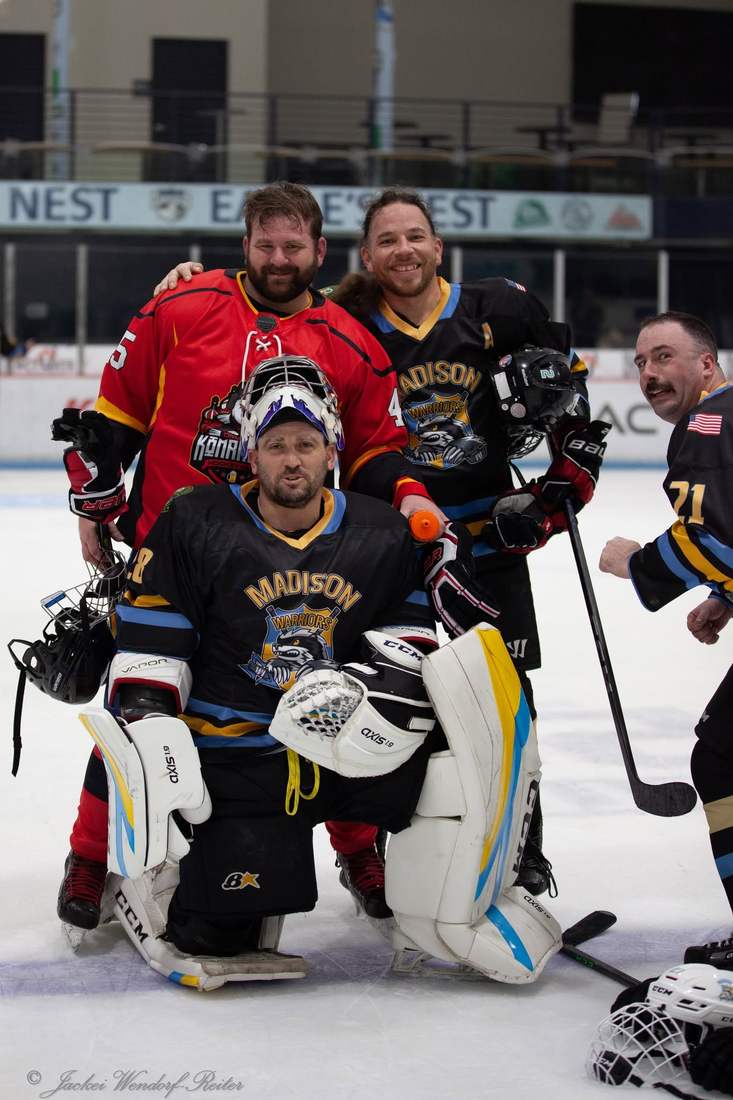 Warriors goalie and teammates pose with a Comrades player after the game