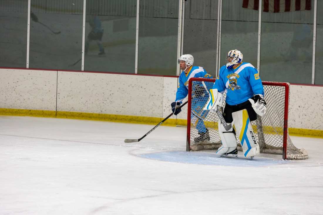 Warriors goalie #28 and a defenseman guard the net